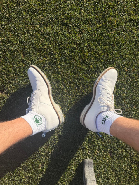 White sneakers and socks on a grassy surface